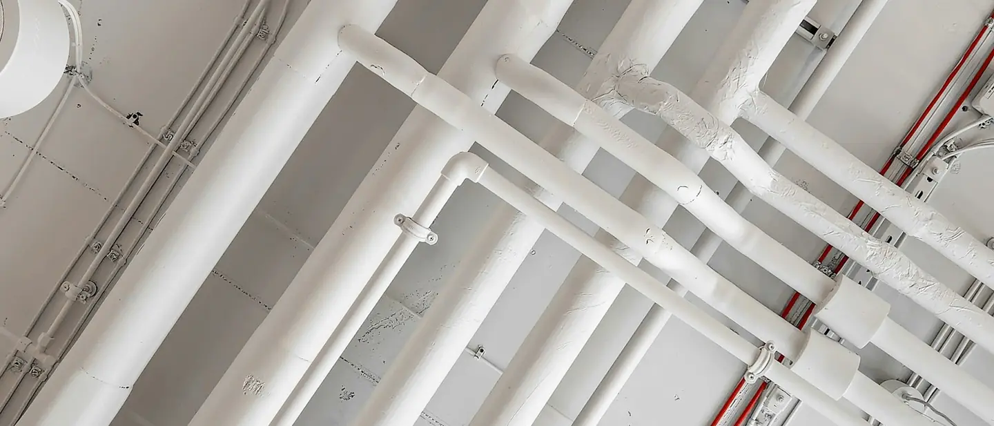 Runs of electrical conduit across an industrial ceiling