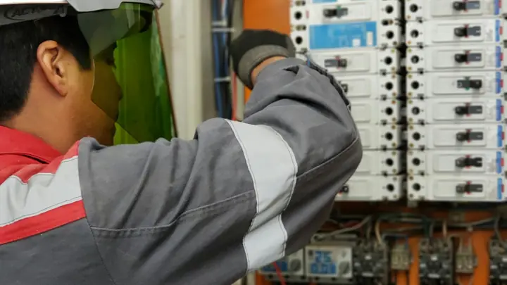 Electrician testing a bank of electrical panels